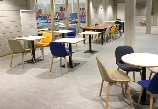 Slick en Club tafels om aan te zitten in het souterrain met uitzicht op de sporthal