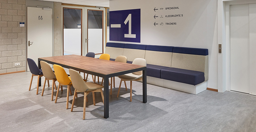 Slick tafel met Jami 4-poot stoelen in de wachtruimte van de sportaccommodatie