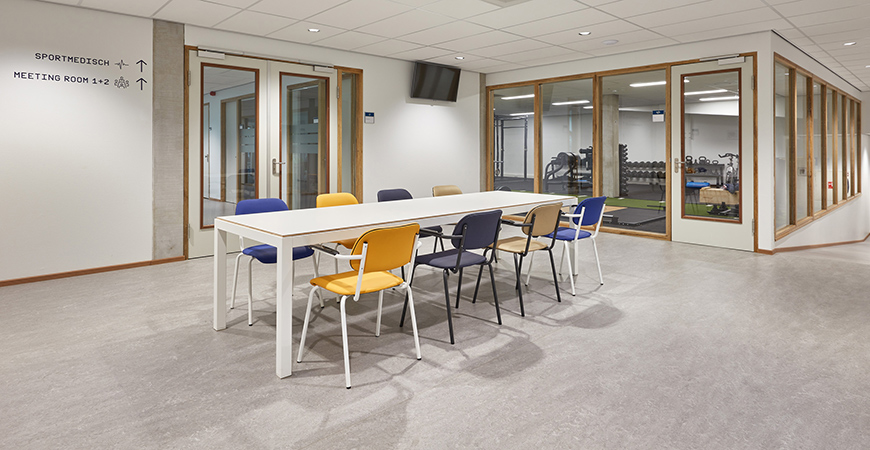 Inrichting sportaccommodatie kantine met witte Slick tafel en Jami 4-poot stoelen