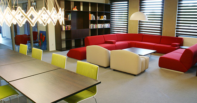 Groen gestoffeerde X-Ray stoelen aan een Club tafel en op de achtergrond Artifort banken